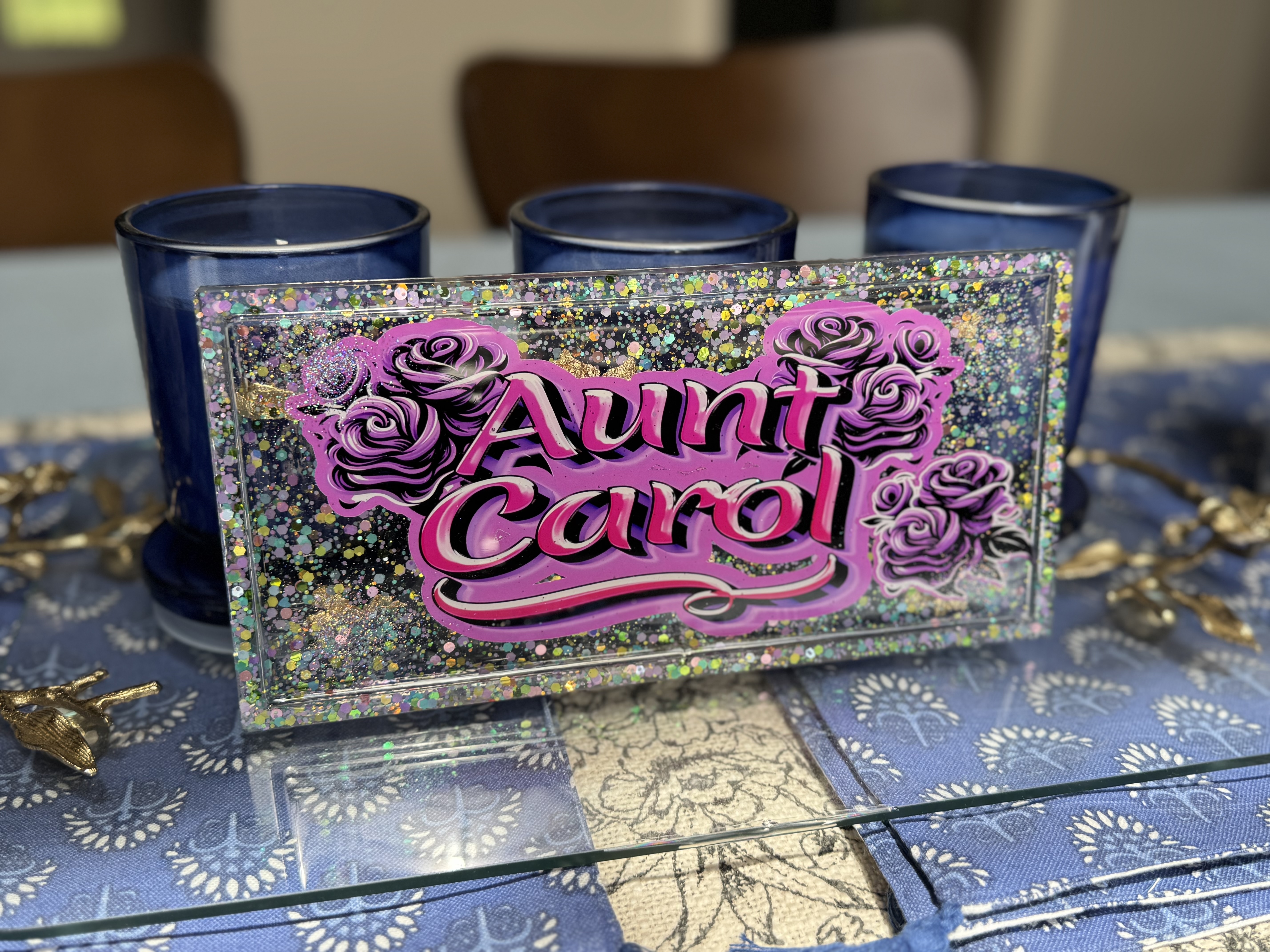 A rectangular resin trinket tray with glitter and purple roses, personalized with the name 'Aunt Carol' in bold pink script.